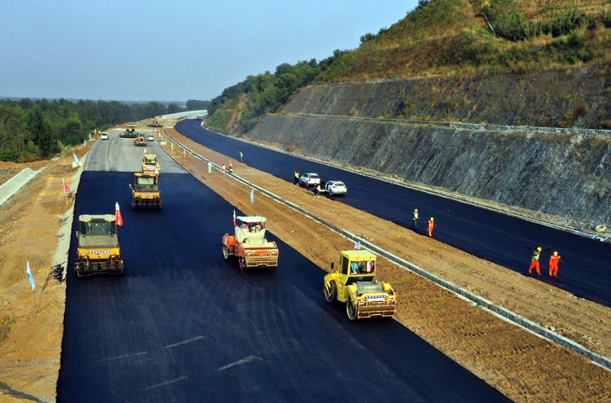 建設(shè)中的遵化至秦皇島高速公路遷安段B4標段70％超高摻量膠粉瀝青下面層試驗段鋪筑。 樊連貴攝