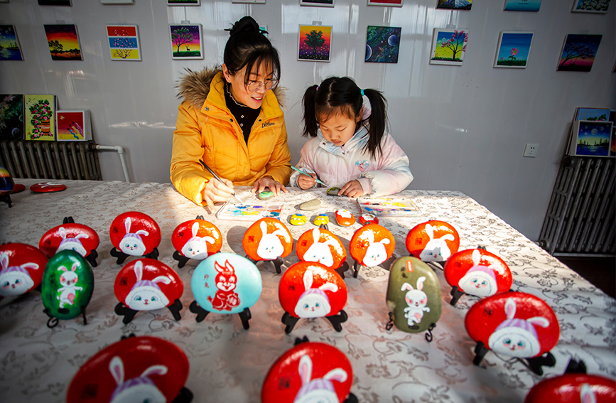 河北省邯鄲市復(fù)興區(qū)戶村鎮(zhèn)林村農(nóng)家女宿靜正在輔導(dǎo)小朋友創(chuàng)作石頭畫。 聶長青攝