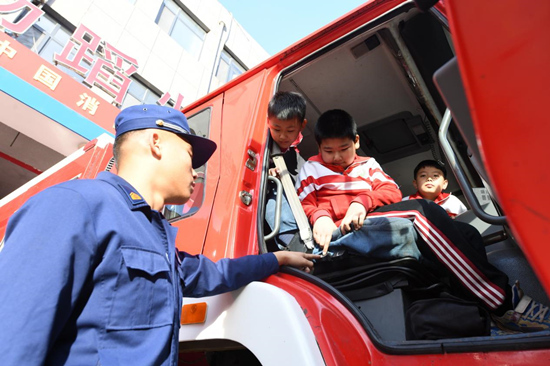 在文安縣消防救援大隊(duì)，孩子們登上消防車參觀。 郭小婧攝