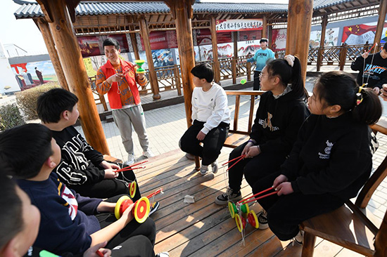 在文安縣大留鎮(zhèn)小學(xué)紅色文化教育基地，志愿者正在向孩子們介紹抖空竹的基本動(dòng)作。 高丹鈺攝