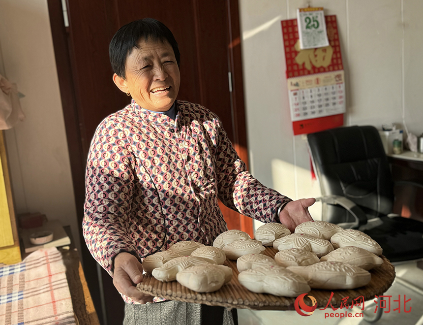 張瑞霞捧著剛出鍋的面花，開心地笑著。人民網(wǎng)記者 方童攝