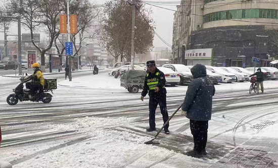 蓮池區(qū)，城管隊員協(xié)助沿街商戶清理積雪。王強攝