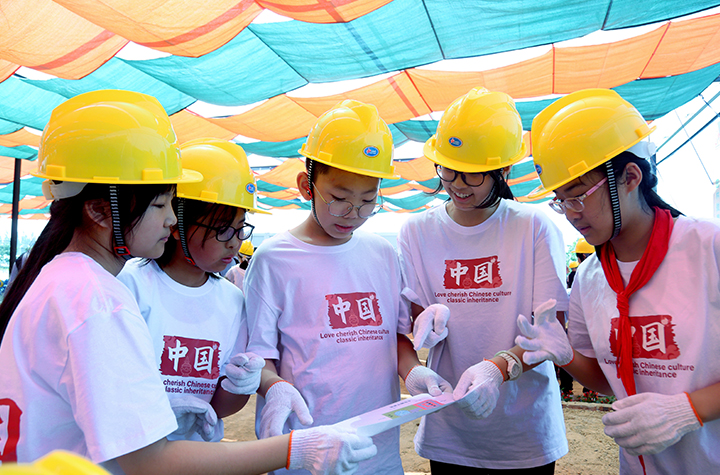 勞動研學實踐體驗活動現(xiàn)場，學生們一起研究微型景觀建造圖紙