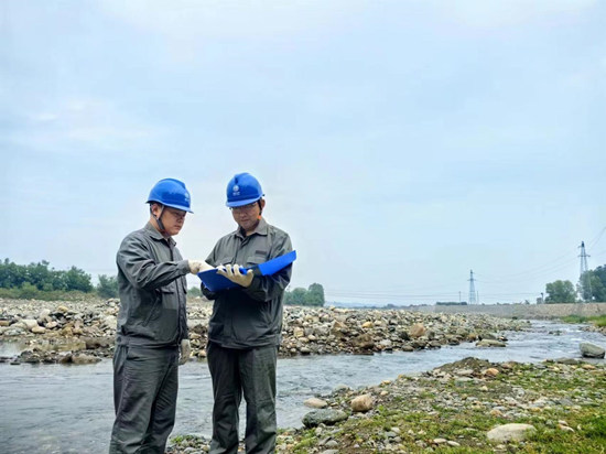 國網(wǎng)贊皇縣供電公司工作人員巡檢河道周邊電力設(shè)施。王一蘭攝