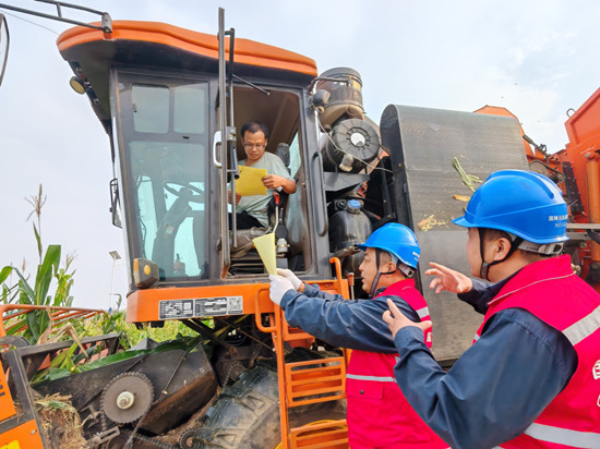 國網(wǎng)元氏縣供電公司員工在鐵屯村向收割機(jī)駕駛員宣傳安全用電常識(shí)。劉美君攝