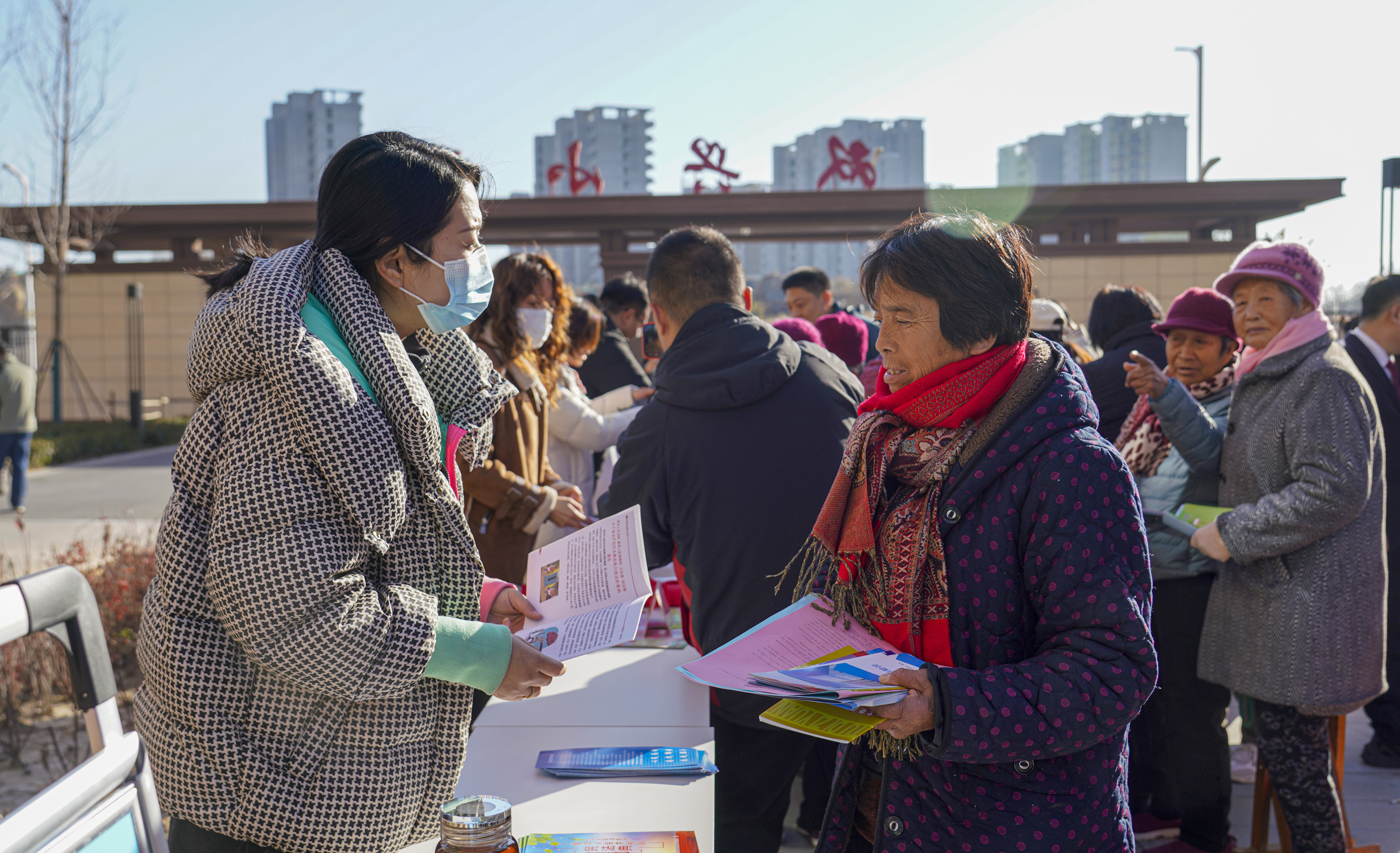 工作人員向居民發(fā)放法律宣傳資料。王穎攝