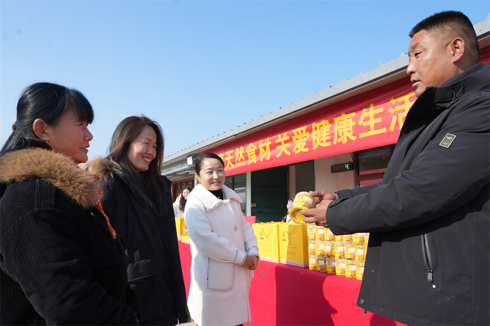 12月8日，隆堯縣東良鎮(zhèn)黃營(yíng)村黨支部書記馮建勇在向游客介紹本村生產(chǎn)的金絲黃菊茶。楊秋芳攝