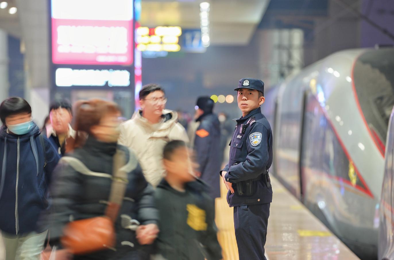 G6742次列車乘警李雪曉在石家莊站站臺(tái)上站崗，守護(hù)著旅客列車的安全。賈義涵攝