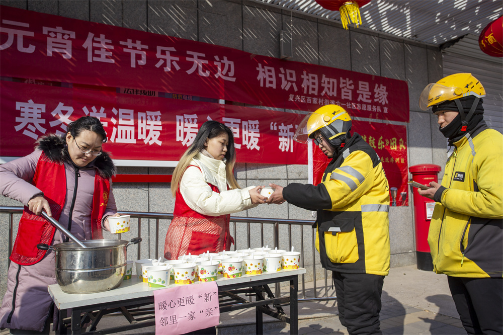 2月10日，河北省邯鄲市復(fù)興區(qū)百家村街道六一社區(qū)志愿者為快遞員、外賣騎手等一線戶外勞動者送元宵。聶長青攝